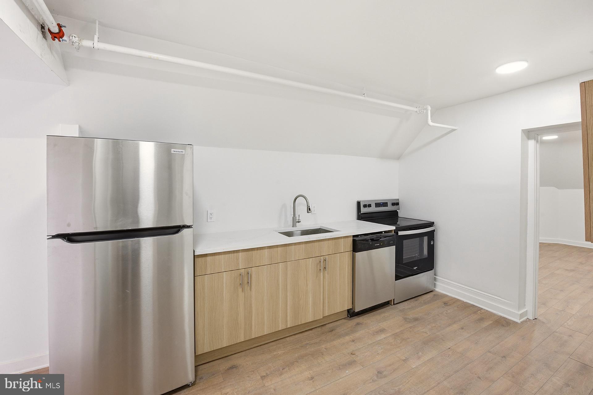 6012 Ridge Avenue, Unit 8 Philadelphia, PA 19128 - Photo 3 of 17 a kitchen with stainless steel appliances a refrigerator and a sink