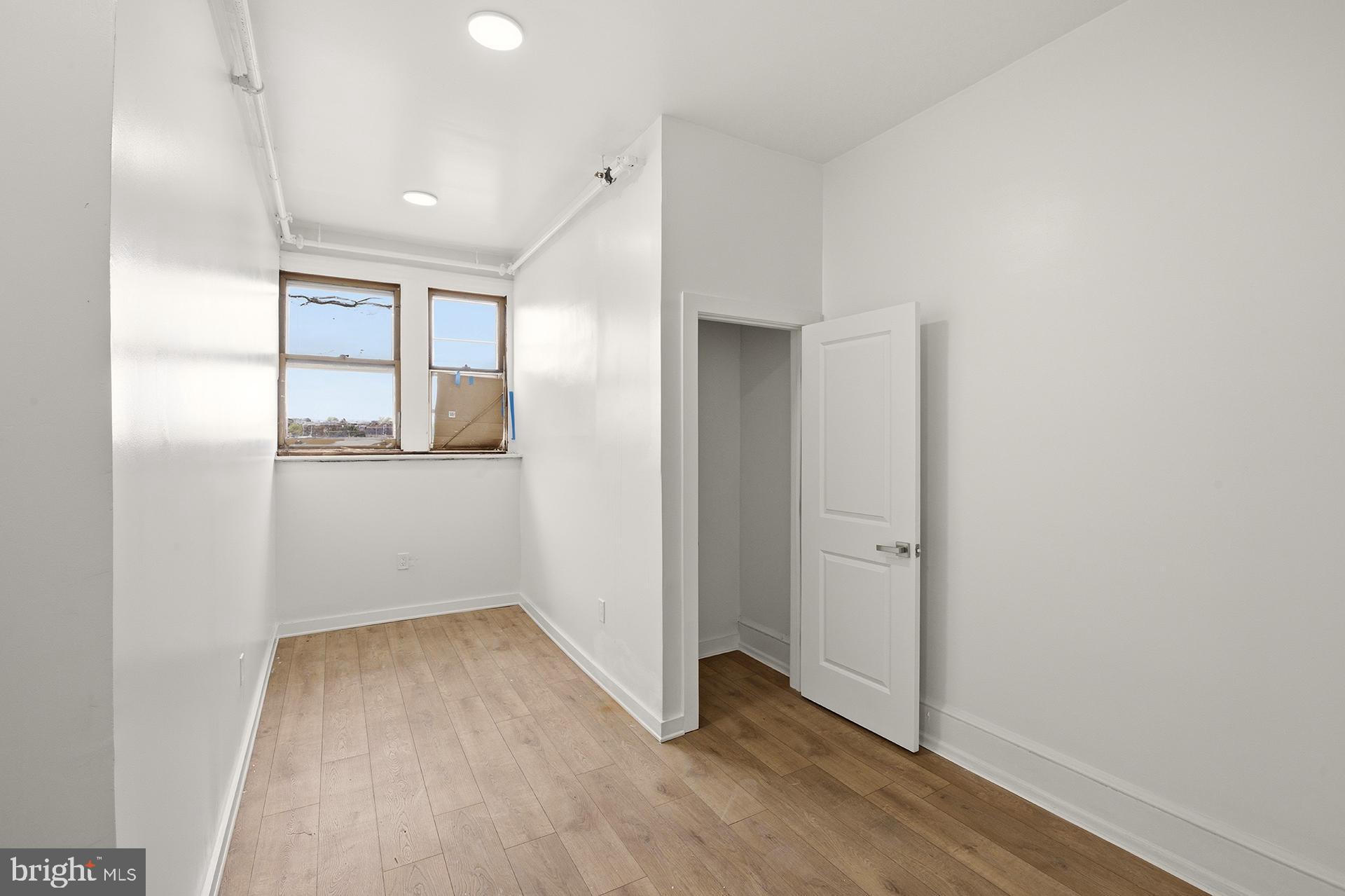 6012 Ridge Avenue, Unit 8 Philadelphia, PA 19128 - Photo 9 of 17 an empty room with wooden floor and windows