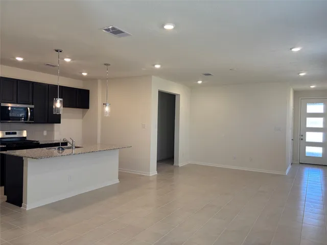 a kitchen with stainless steel appliances granite countertop a refrigerator and a stove top oven