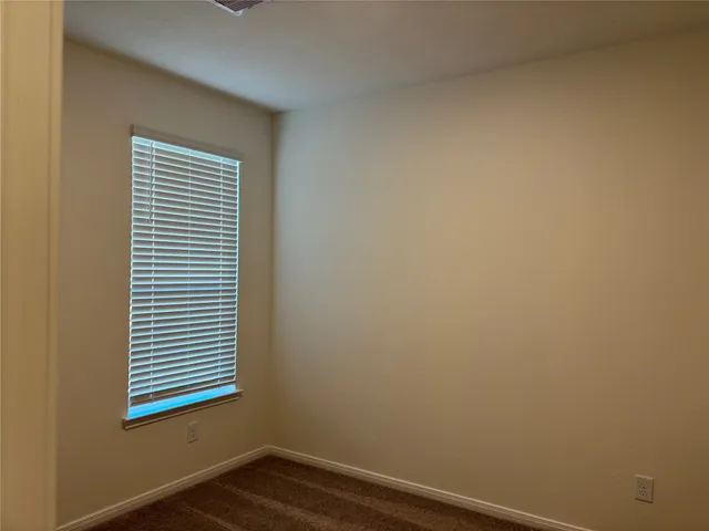 a view of a small space with wooden floor and a window