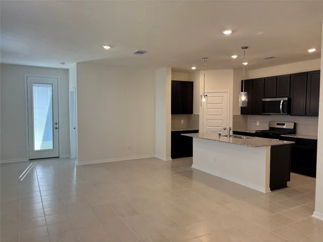 a kitchen with stainless steel appliances granite countertop a refrigerator and a stove top oven