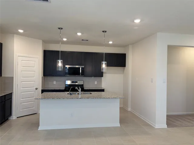 a large white kitchen with a sink and a refrigerator