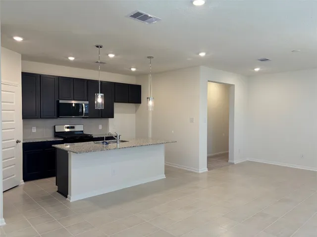 a kitchen with stainless steel appliances granite countertop a sink and a stove