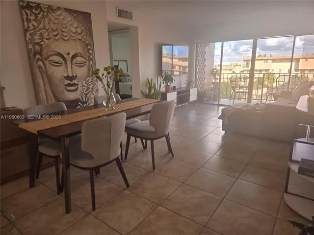a dining room with furniture and a floor to ceiling window