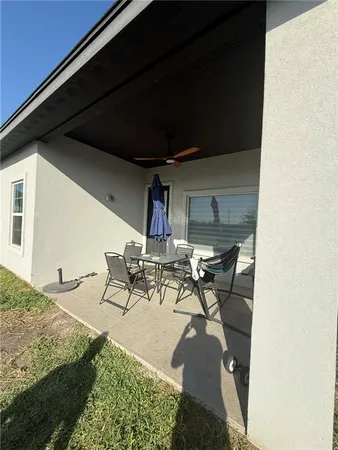 a view of a backyard with table and chairs under an umbrella