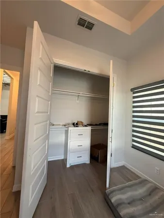 a kitchen with white cabinets and wooden floor