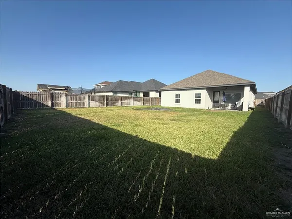 a view of a big house with a big yard and palm trees