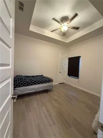 en empty room with wooden floor and ceiling fan
