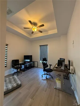 a view of a workspace with furniture and a window