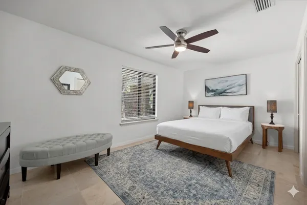 a bedroom with a bed table and window