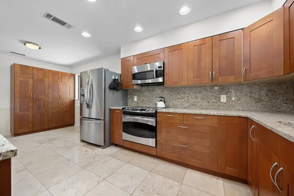 a kitchen with stainless steel appliances granite countertop a refrigerator and a sink