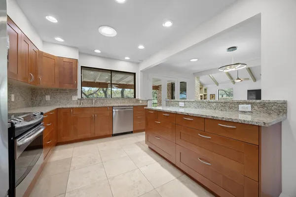 a kitchen with granite countertop a stove and cabinets