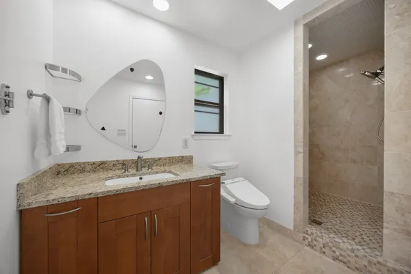 a bathroom with a granite countertop sink a toilet and a mirror