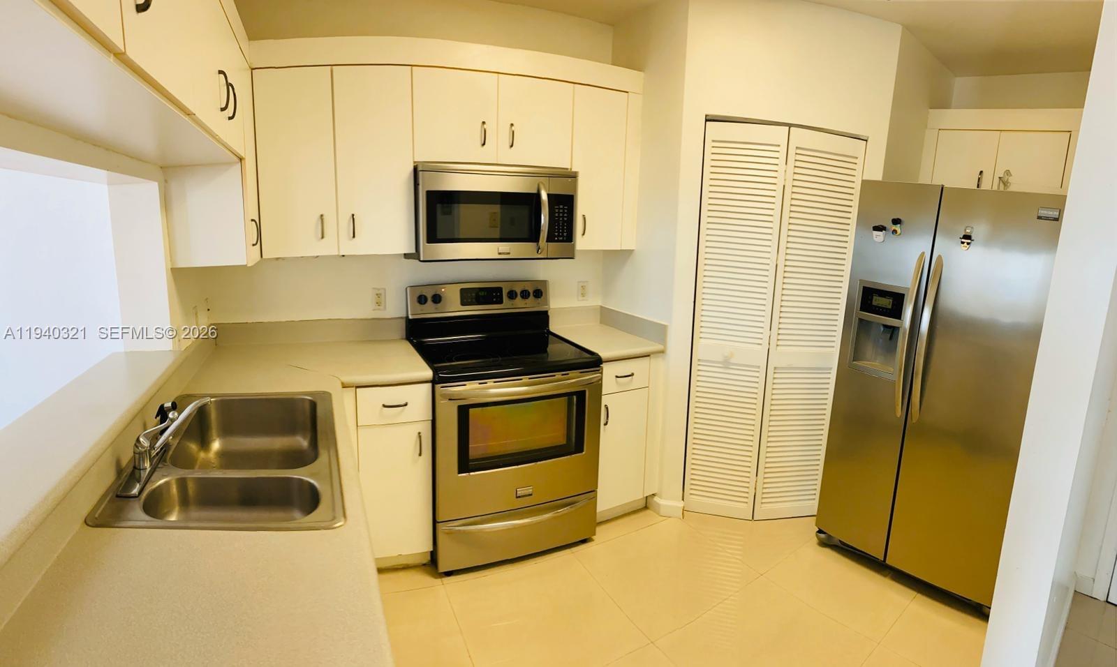 701 Brickell Key Boulevard, Unit LPH01 Miami, FL 33131 - Photo 5 of 15 a kitchen with stainless steel appliances a stove a microwave and a refrigerator