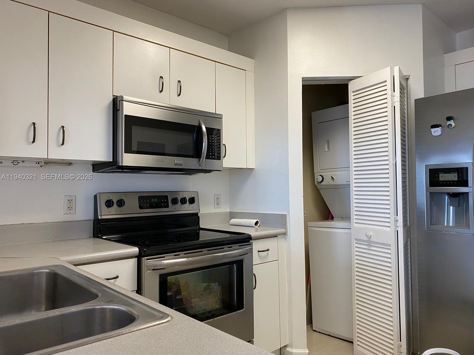 701 Brickell Key Boulevard, Unit LPH01 Miami, FL 33131 - Photo 7 of 15 a kitchen with stainless steel appliances a stove microwave and sink