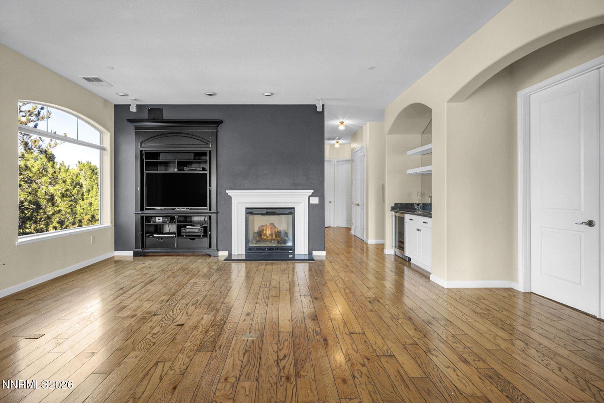 9900 Wilbur May Parkway, Unit 2504 Reno, NV 89521 - Photo 16 of 78 an empty room with wooden floor fireplace and windows