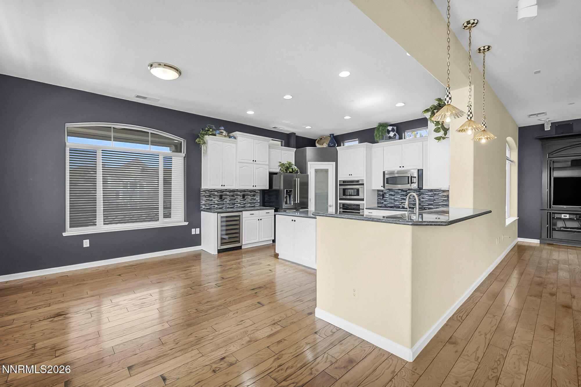 9900 Wilbur May Parkway, Unit 2504 Reno, NV 89521 - Photo 8 of 78 a kitchen with stainless steel appliances kitchen island wooden floors and white cabinets