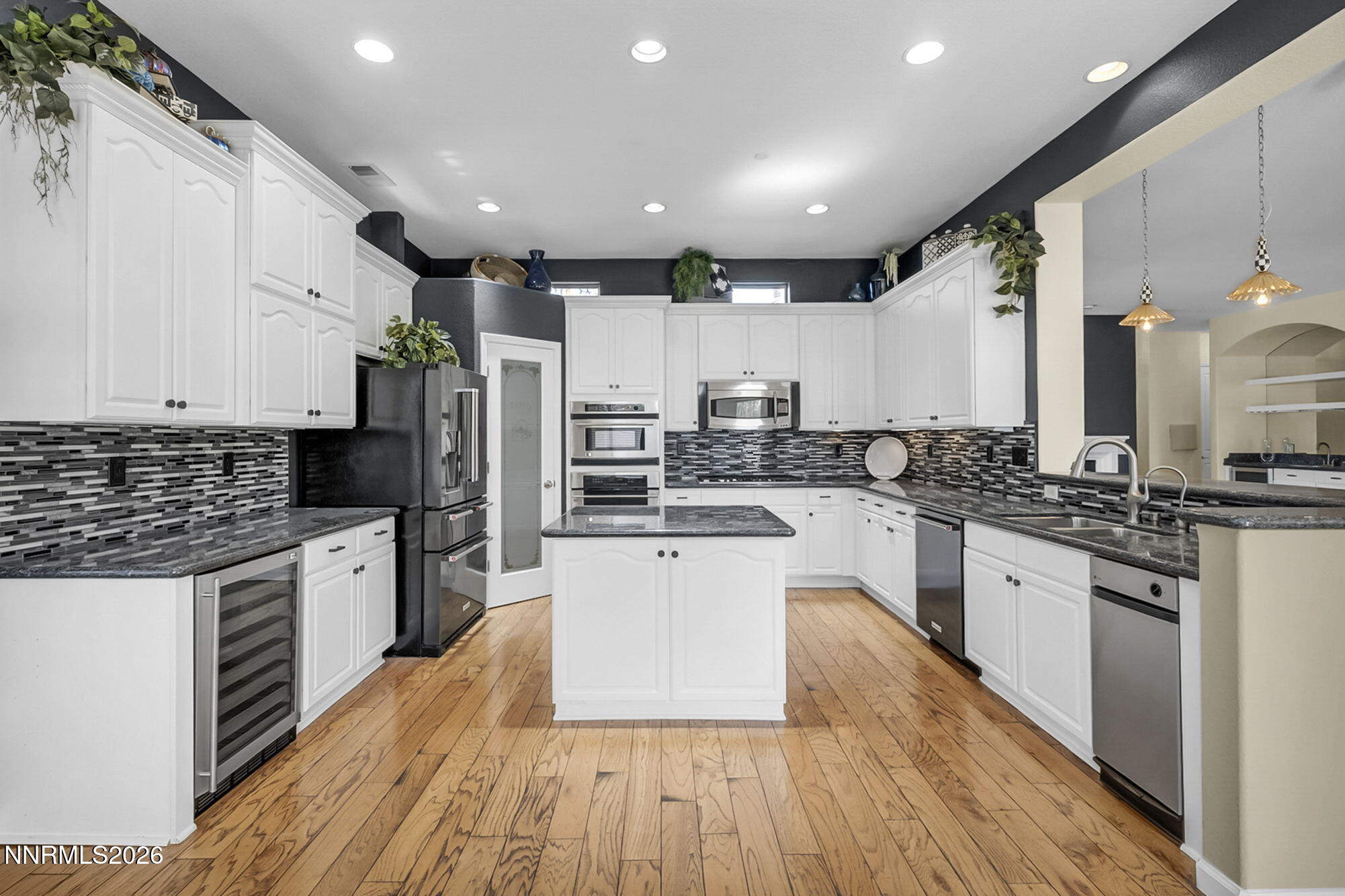 9900 Wilbur May Parkway, Unit 2504 Reno, NV 89521 - Photo 9 of 64 a large kitchen with stainless steel appliances lots of counter space and wooden floor