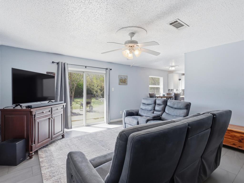 3228 Hummingbird Lane Denton, TX 76209 - Photo 13 of 27 a living room with furniture and a flat screen tv