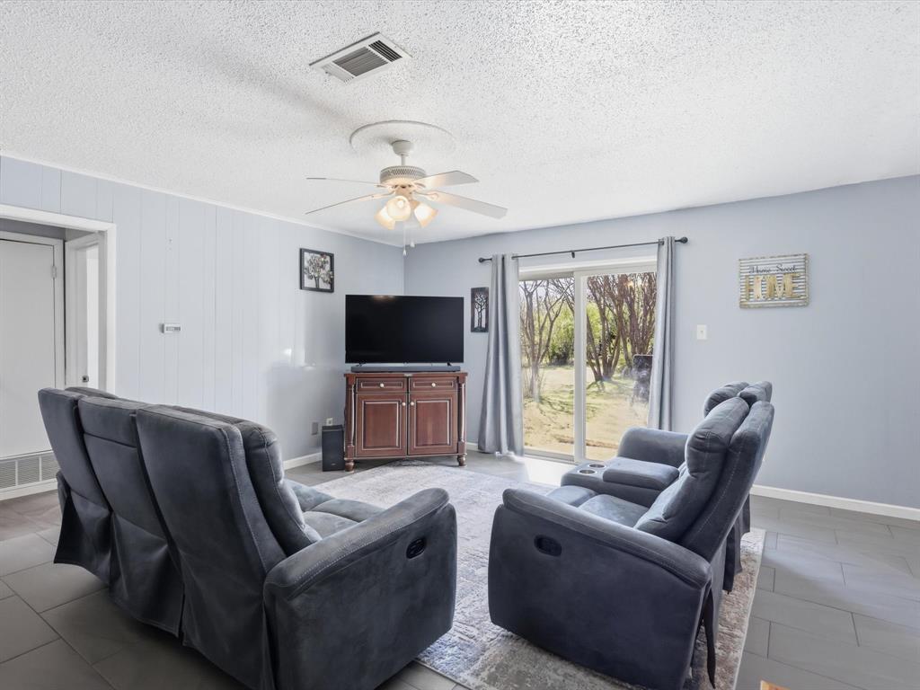 3228 Hummingbird Lane Denton, TX 76209 - Photo 14 of 27 a living room with furniture a flat screen tv and a window