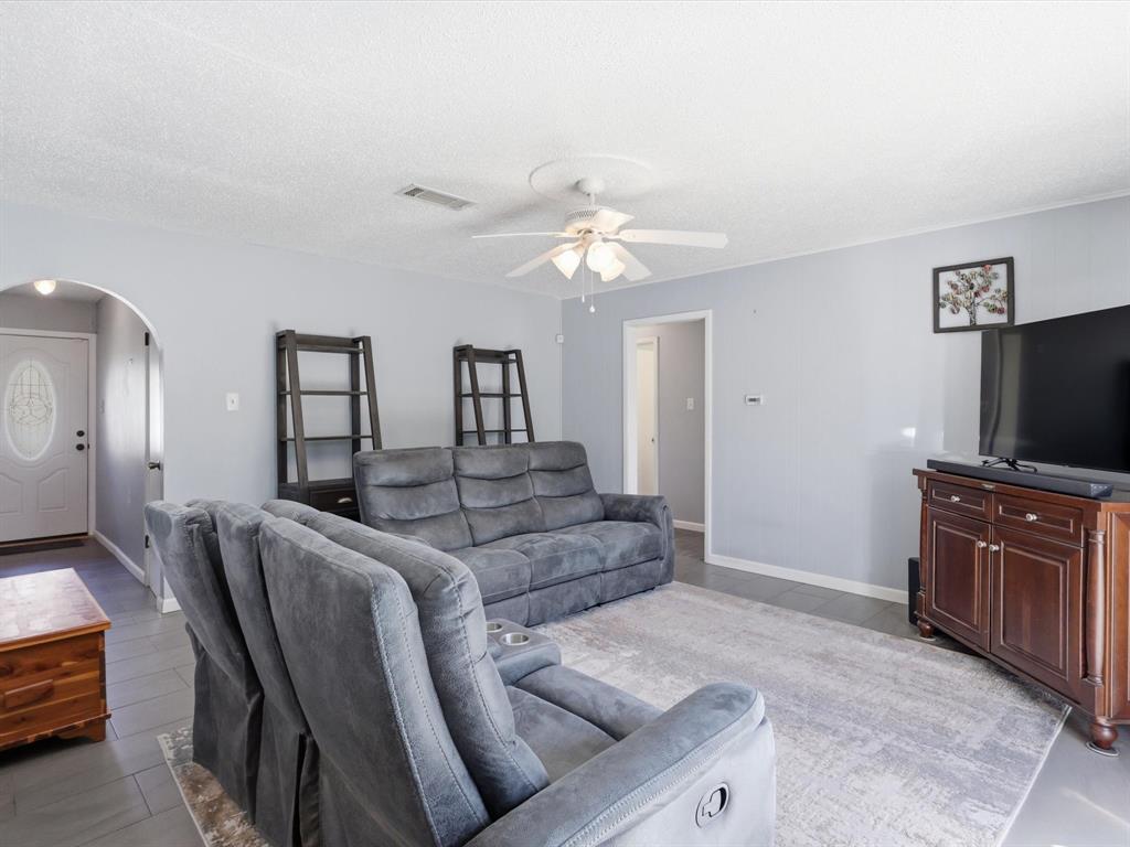 3228 Hummingbird Lane Denton, TX 76209 - Photo 15 of 27 a living room with furniture a flat screen tv and kitchen view