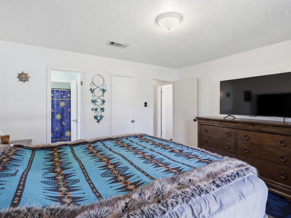 3228 Hummingbird Lane Denton, TX 76209 - Photo 18 of 27 a bedroom with a bed and a flat screen tv
