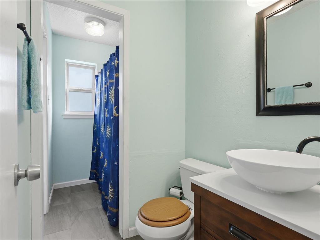 3228 Hummingbird Lane Denton, TX 76209 - Photo 19 of 27 a bathroom with a toilet a sink and shower