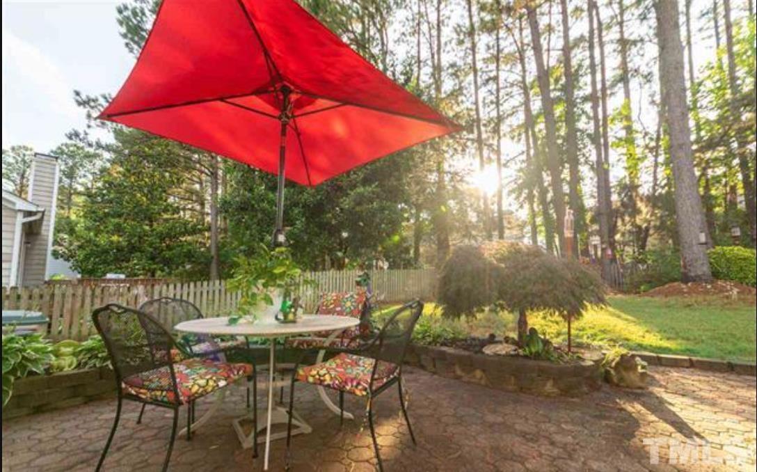 7613 Overland Trail Raleigh, NC 27615 - Photo 17 of 22 a view of a patio with a table and chairs under an umbrella