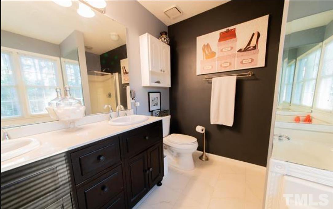 7613 Overland Trail Raleigh, NC 27615 - Photo 6 of 22 a bathroom with a toilet sink and mirror