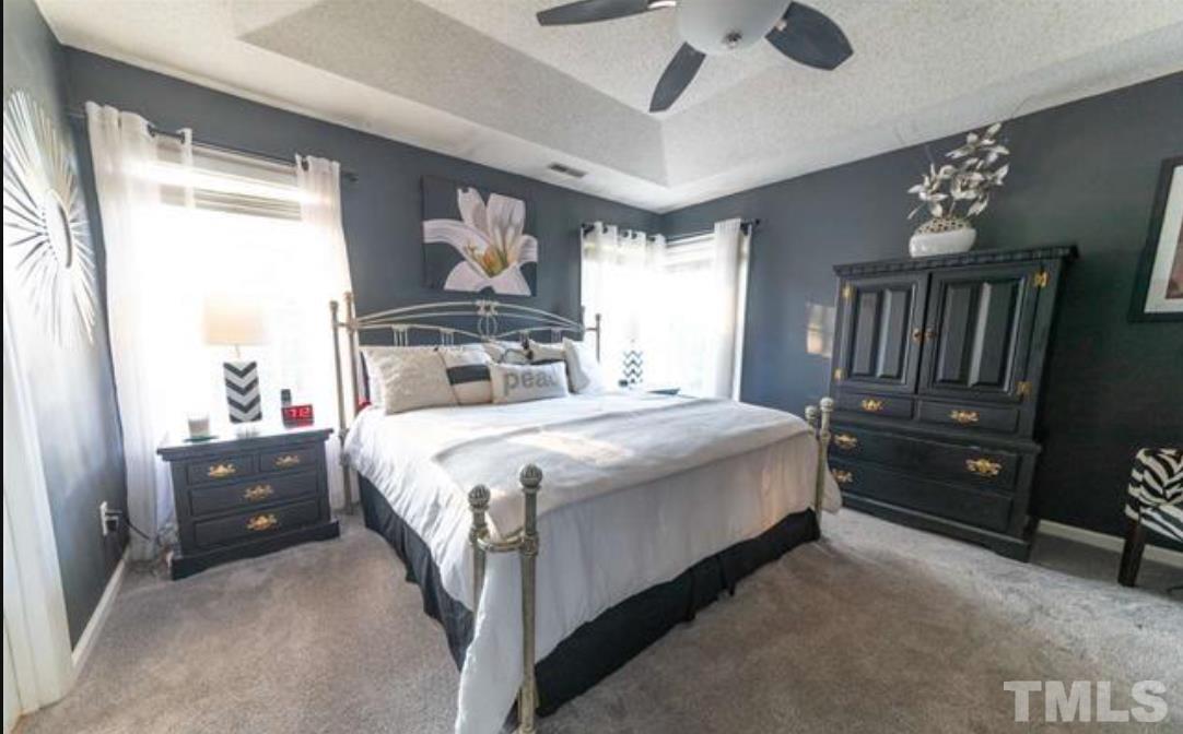 7613 Overland Trail Raleigh, NC 27615 - Photo 8 of 22 a bedroom with a bed lamps and a large mirror