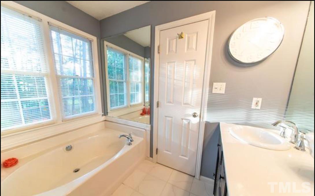 7613 Overland Trail Raleigh, NC 27615 - Photo 9 of 22 a bathroom with a tub sink and mirror