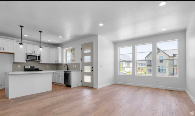 2415 North Ribe Lane Lehi, UT 84048 - Photo 14 of 17 Kitchen with light countertops, open floor plan, a kitchen island, white cabinetry, and stainless steel appliances