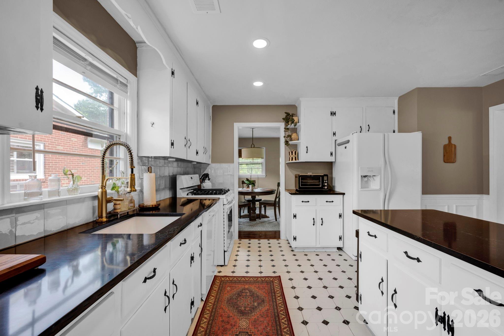 1227 Barkley Road Charlotte, NC 28209 - Photo 14 of 37 a kitchen with granite countertop a sink a stove and refrigerator
