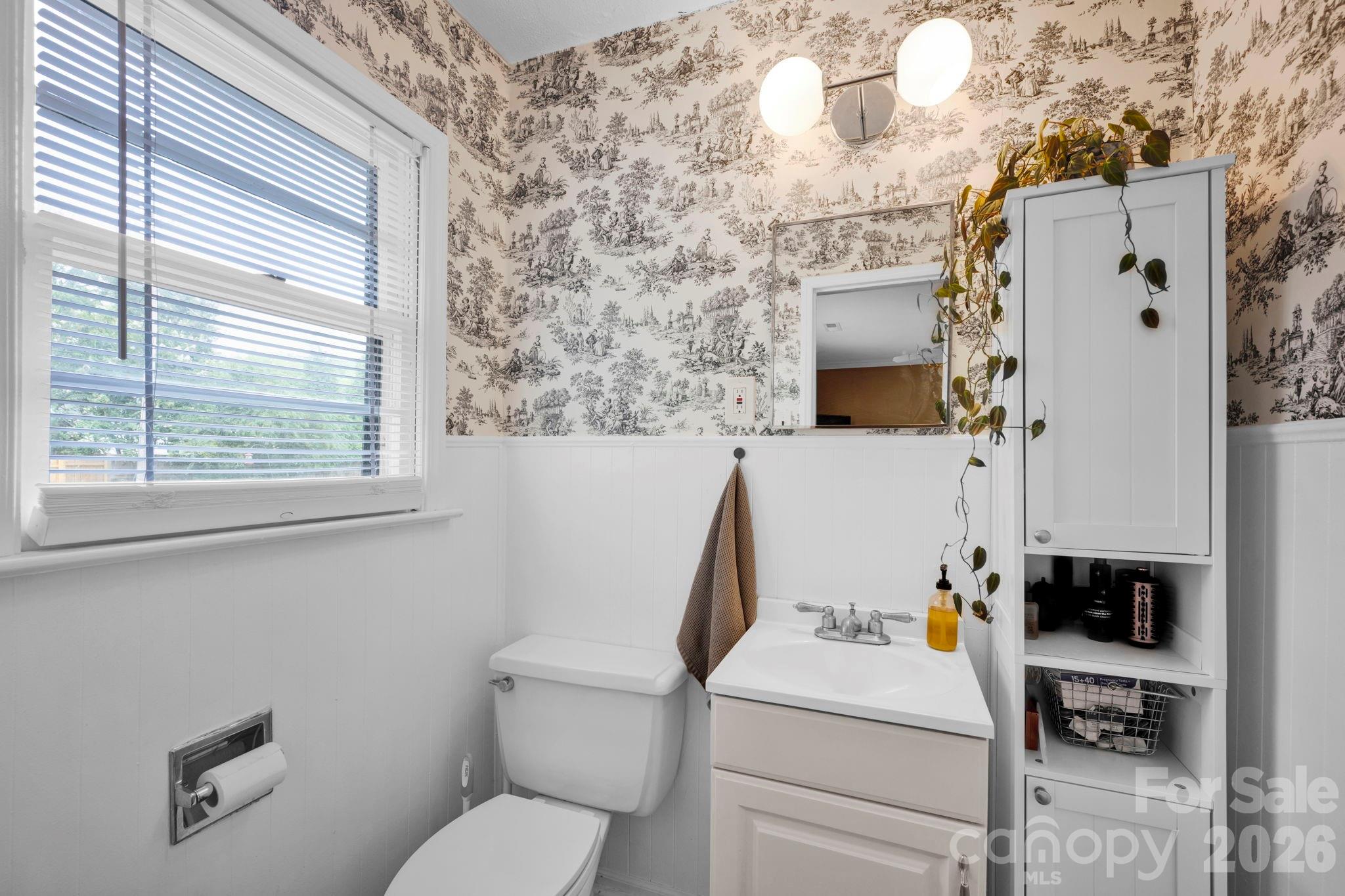 1227 Barkley Road Charlotte, NC 28209 - Photo 20 of 37 a white toilet sitting next to a bathroom sink and a window