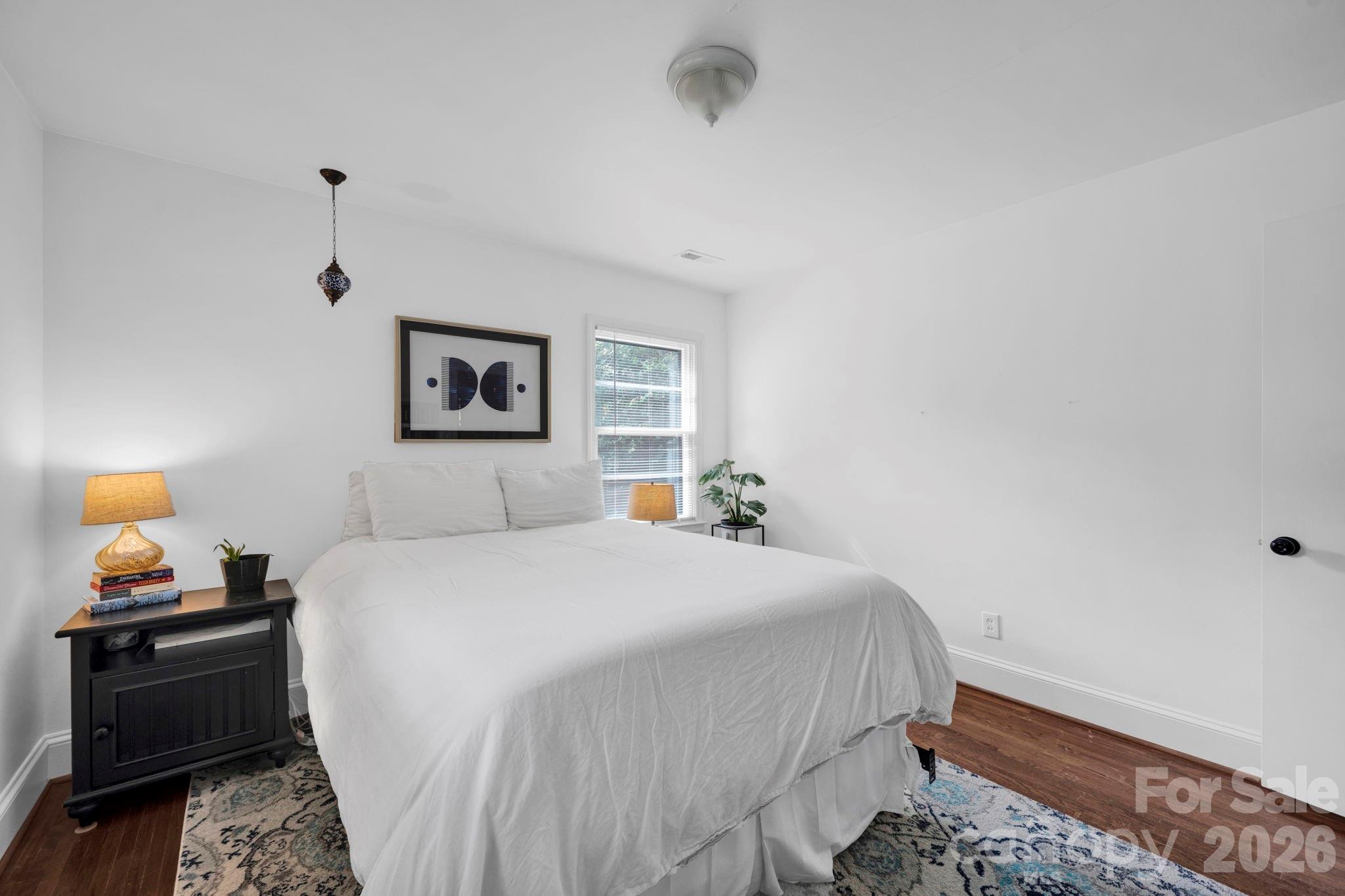 1227 Barkley Road Charlotte, NC 28209 - Photo 21 of 37 a bedroom with a bed and a night stand