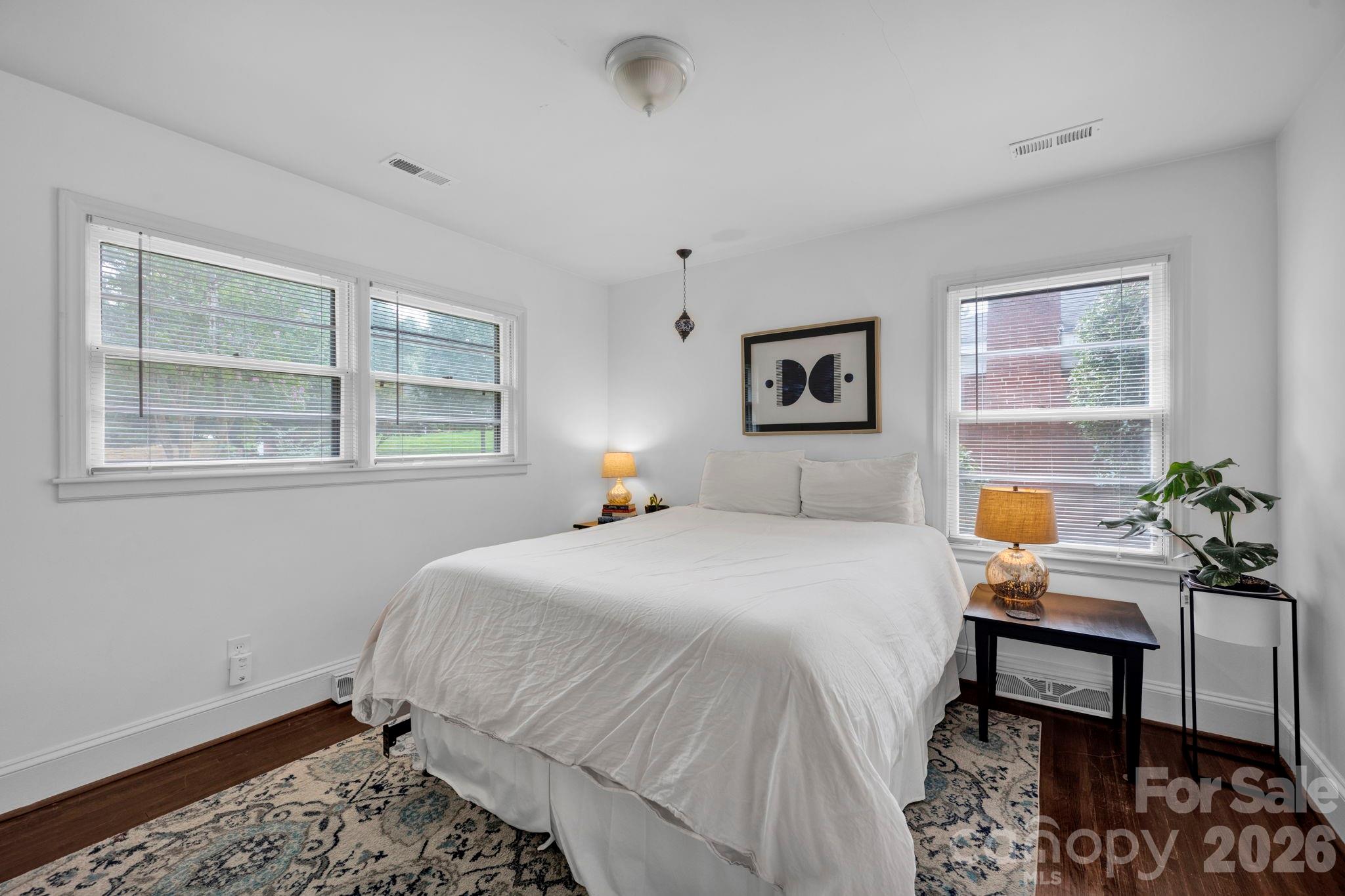 1227 Barkley Road Charlotte, NC 28209 - Photo 22 of 37 a bedroom with a bed table chair and two windows