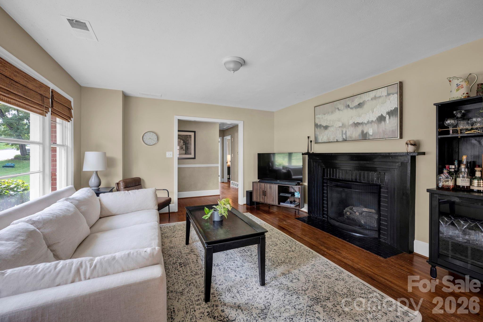 1227 Barkley Road Charlotte, NC 28209 - Photo 3 of 37 a living room with furniture a flat screen tv and a fireplace