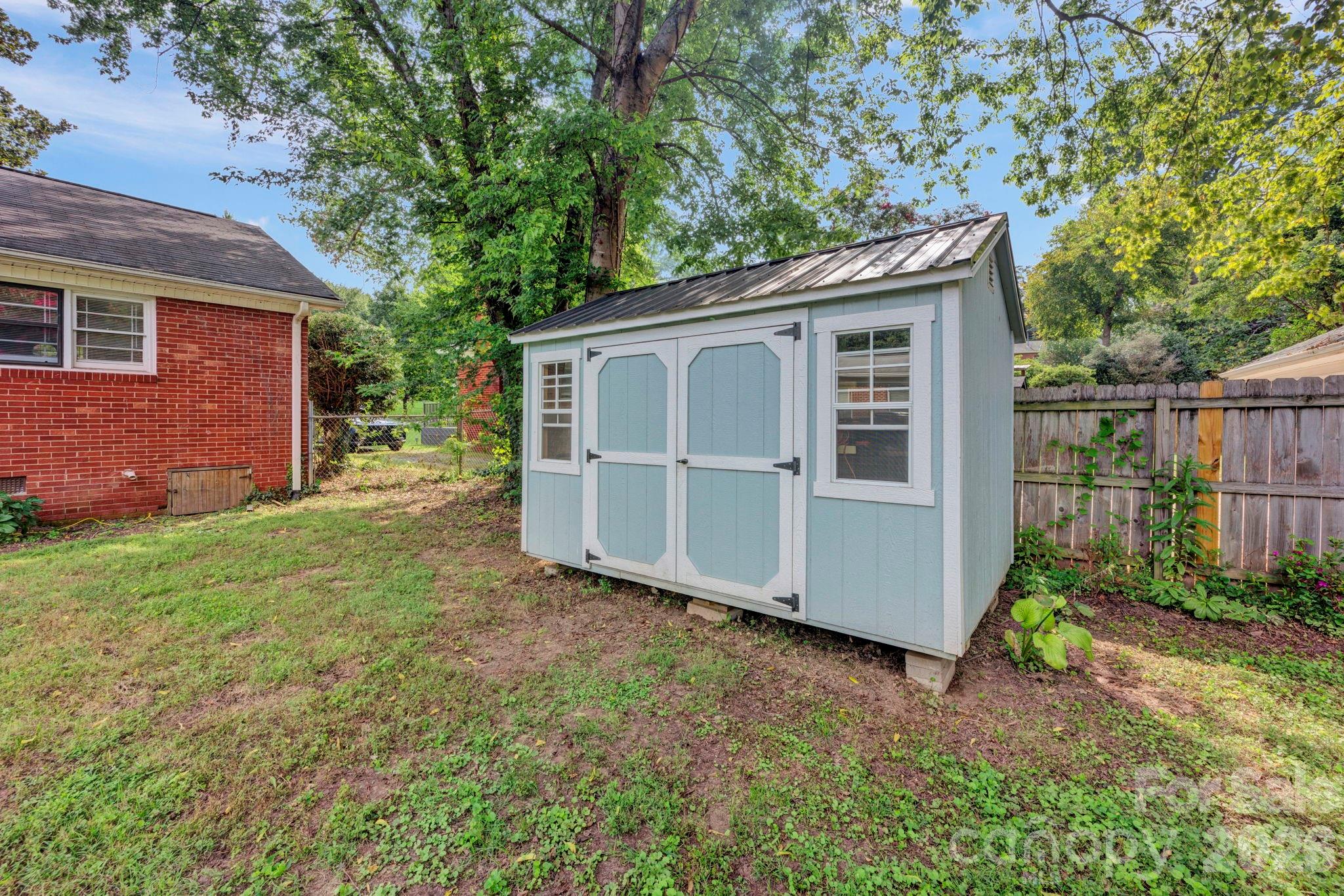 1227 Barkley Road Charlotte, NC 28209 - Photo 32 of 37 a view of backyard of house with wooden fence and large trees