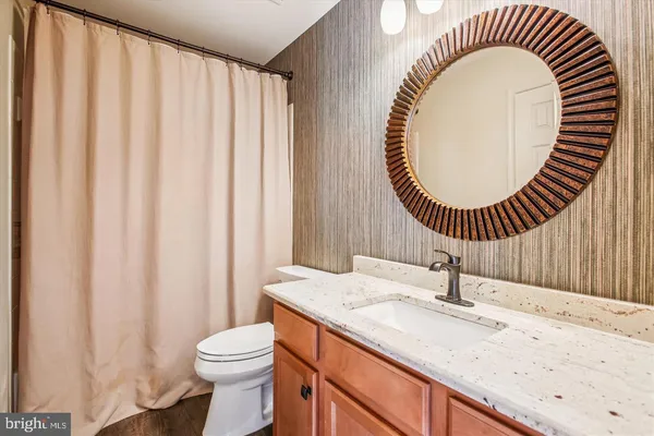 a bathroom with a sink a toilet and a mirror