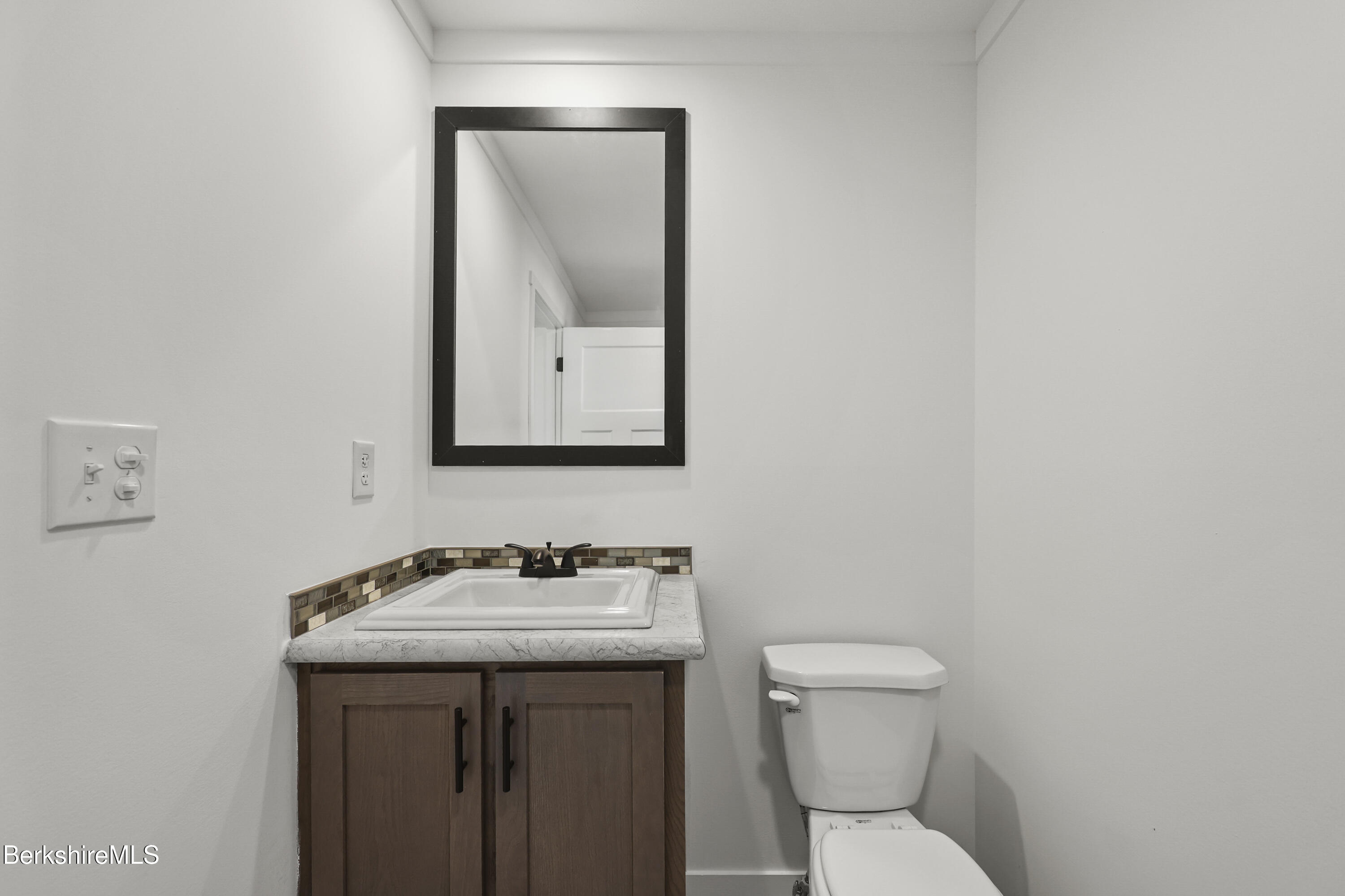 395 Cheshire Road, Unit 102 Pittsfield, MA 01201 - Photo 28 of 28 a bathroom with a toilet a sink and mirror