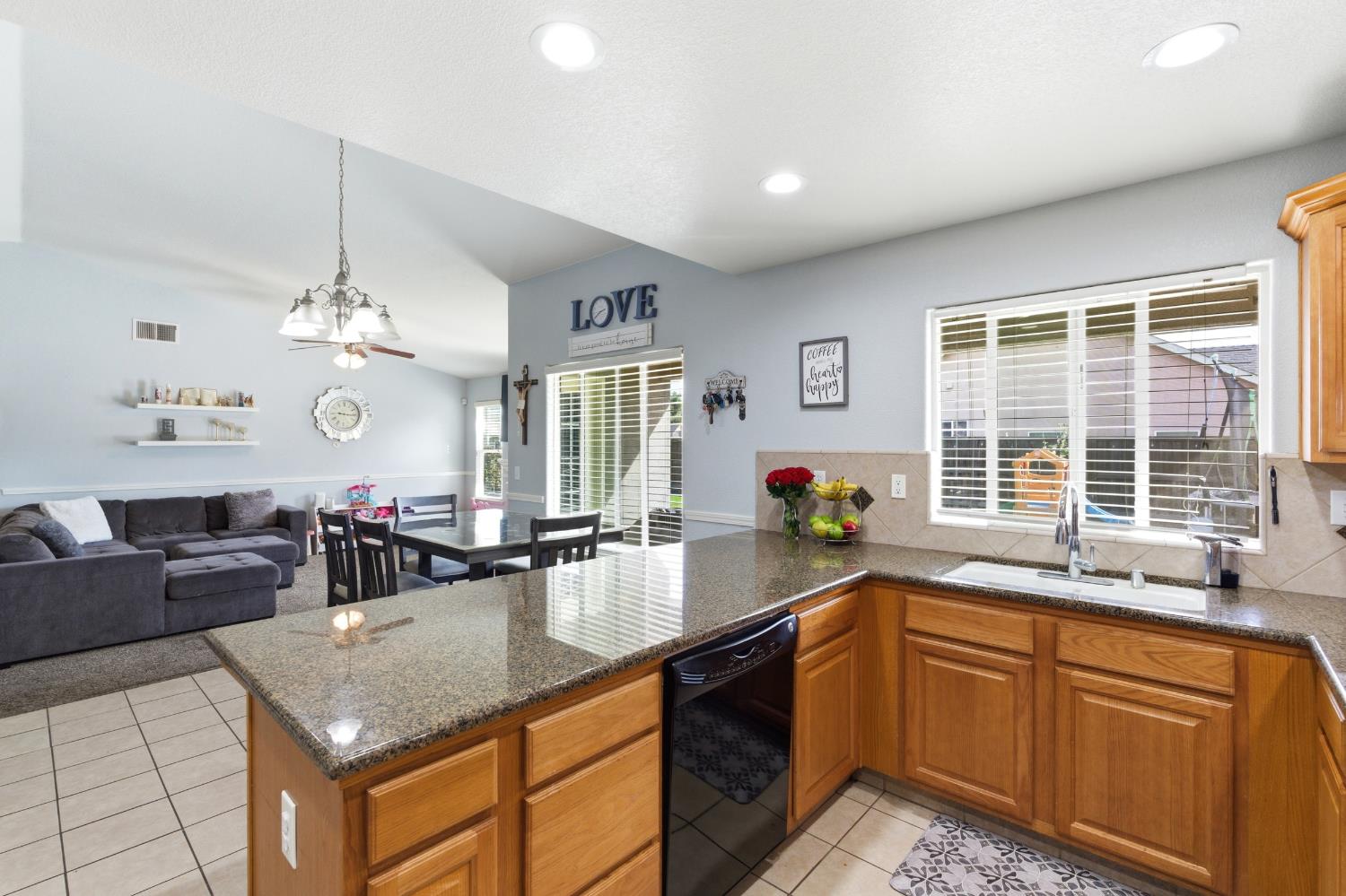 1116 Liberation Way Lemoore, CA 93245 - Photo 12 of 43 a kitchen with granite countertop a sink and white cabinets