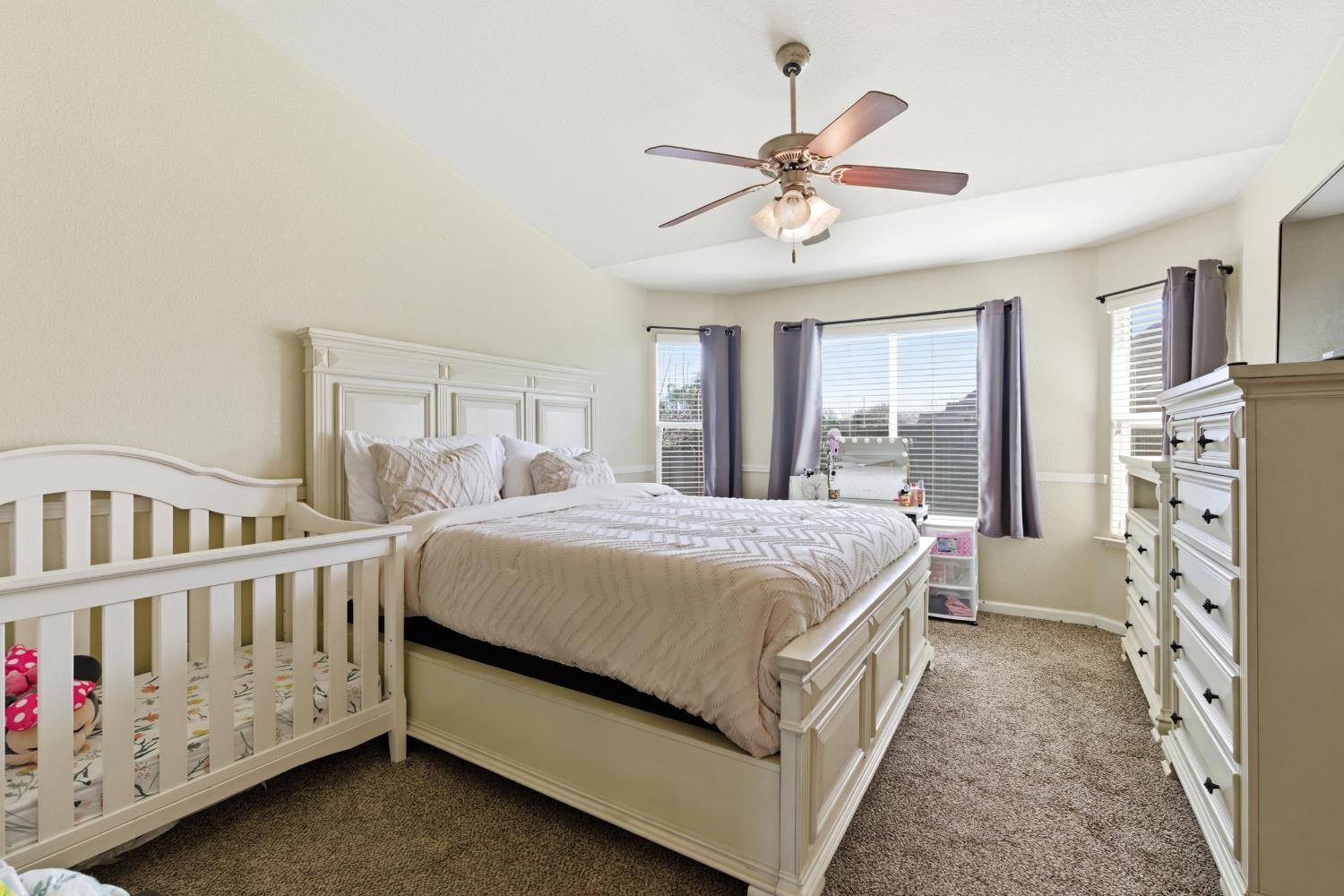 1116 Liberation Way Lemoore, CA 93245 - Photo 16 of 43 a bedroom with a large bed and a chandelier