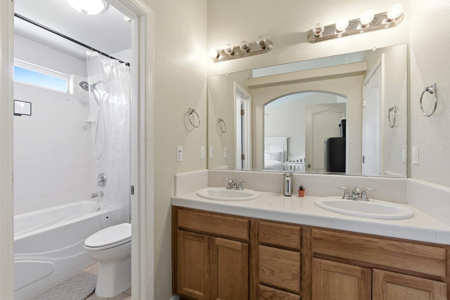 1116 Liberation Way Lemoore, CA 93245 - Photo 18 of 43 a bathroom with a granite countertop sink a toilet and shower