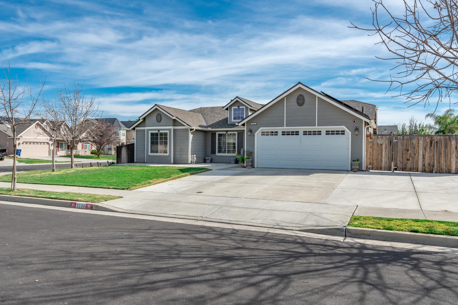 1116 Liberation Way Lemoore, CA 93245 - Photo 2 of 43 a front view of a house with a garden
