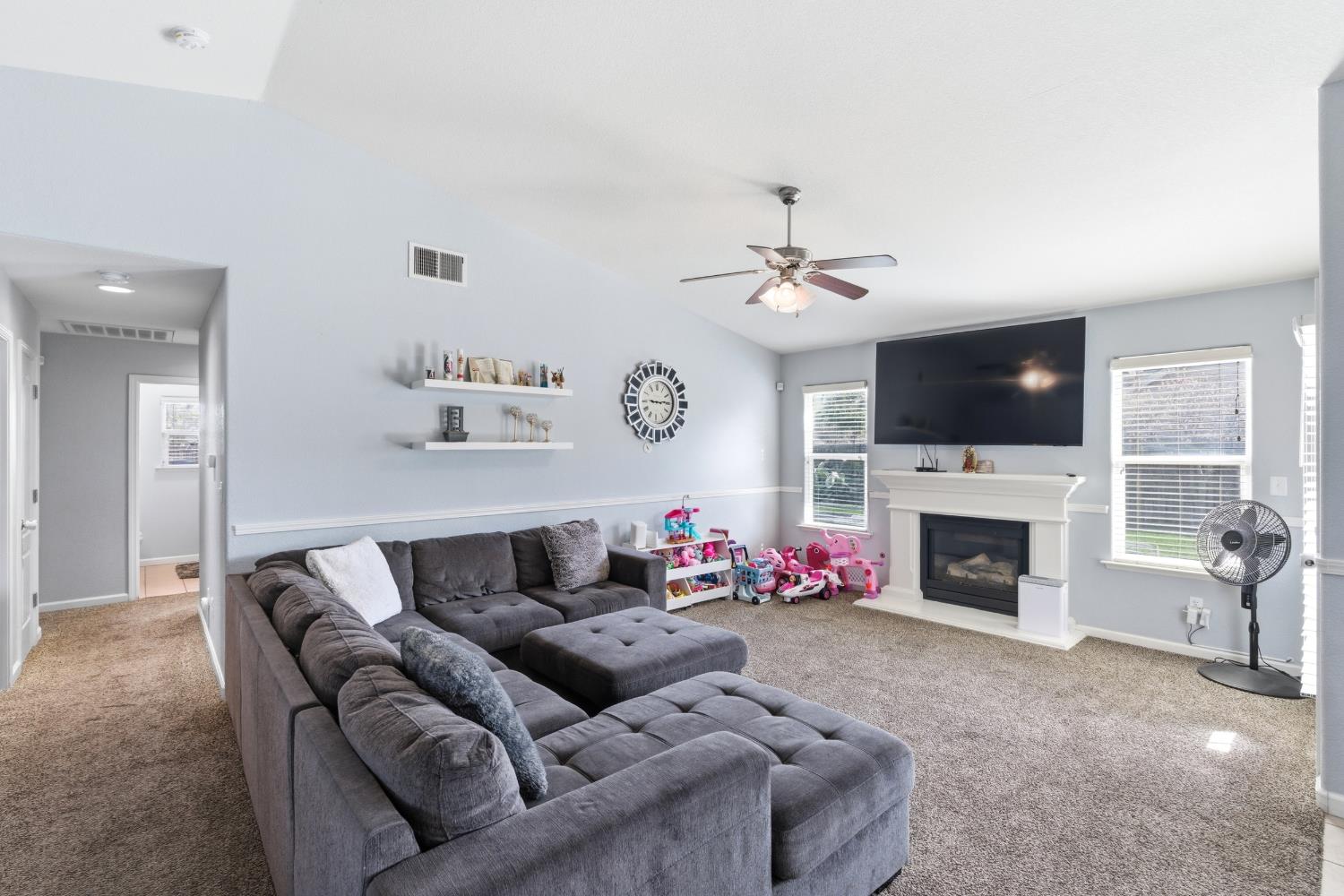 1116 Liberation Way Lemoore, CA 93245 - Photo 22 of 43 a living room with furniture a fireplace and a flat screen tv