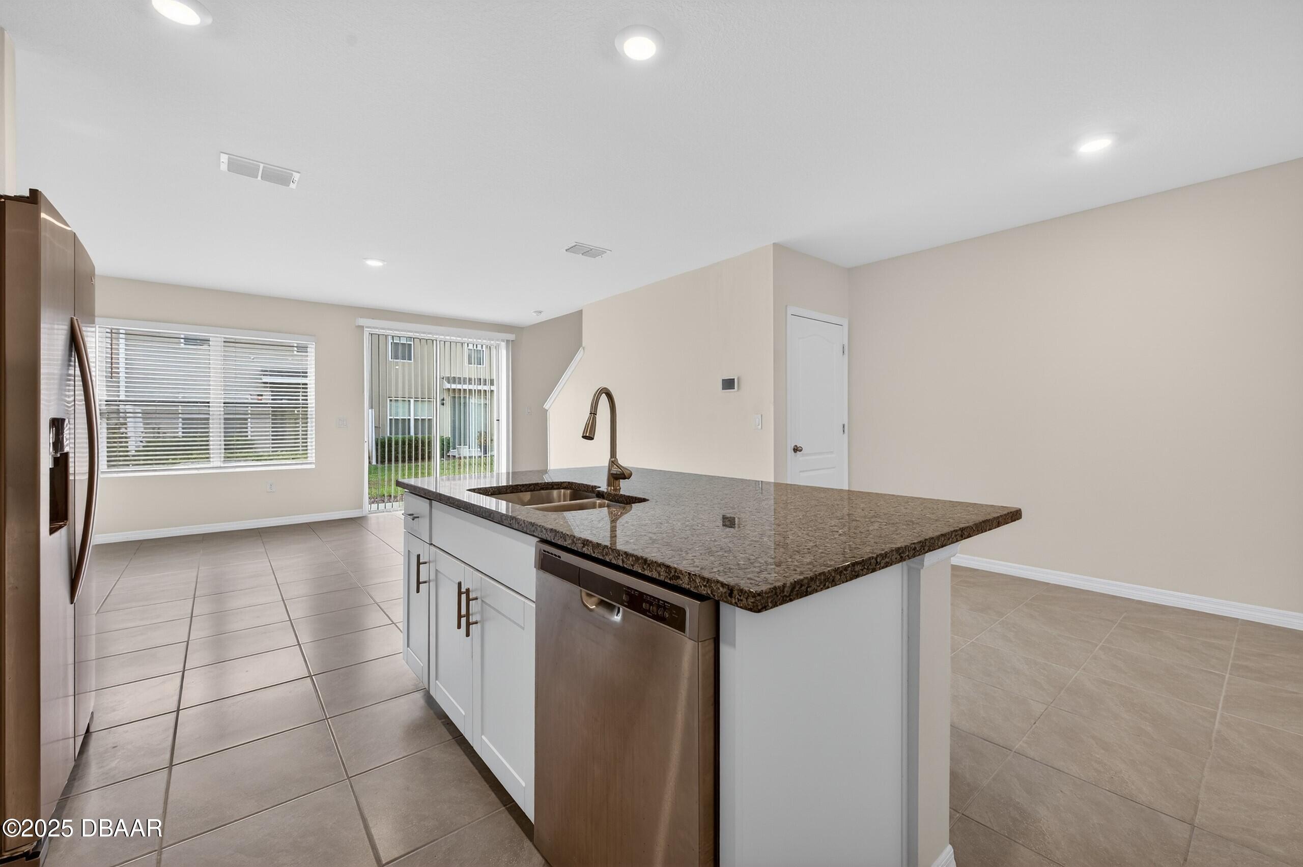 54 Bella Oaks Drive Port Orange, FL 32129 - Photo 9 of 32 a kitchen with stainless steel appliances granite countertop a sink and a stove top oven