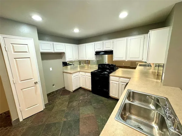 a kitchen with a sink a stove a refrigerator a washer dryer and cabinets