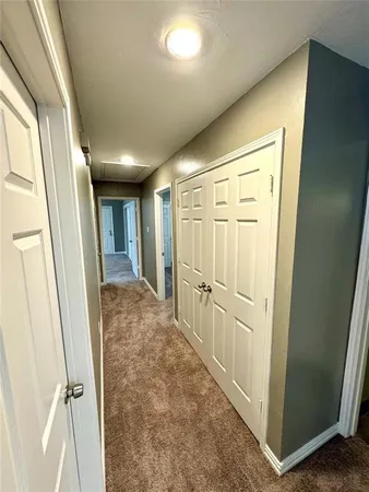 a view of a hallway with wooden floor and cabinet