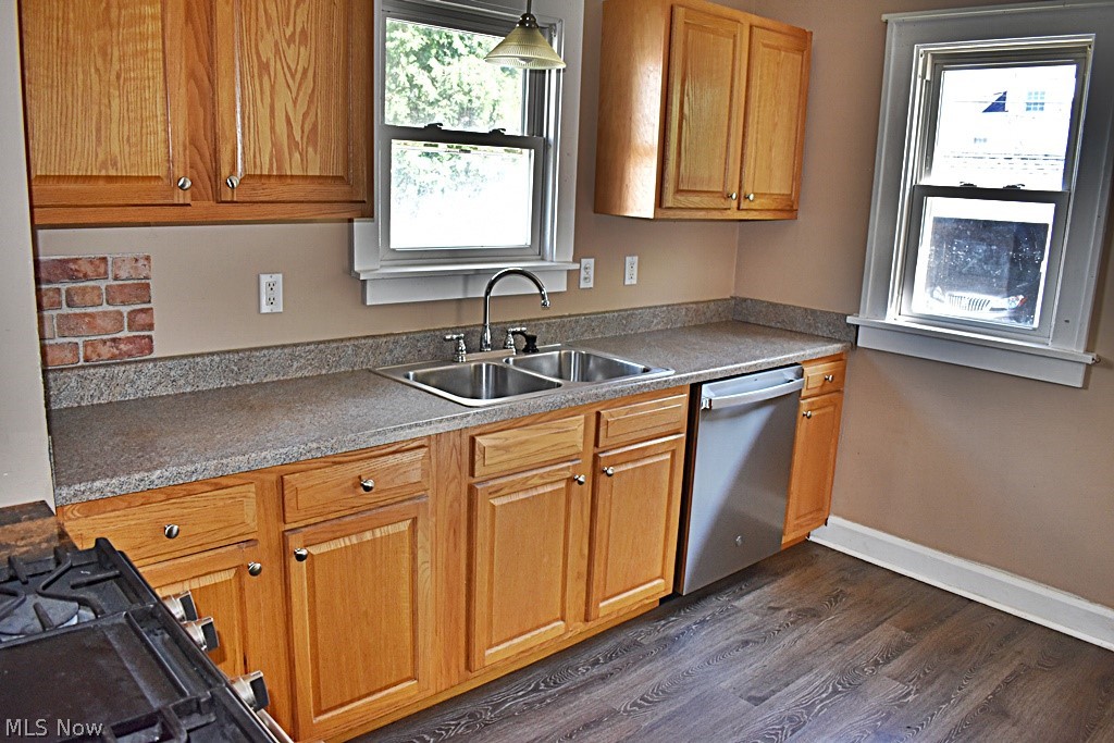 7715 Ackley Road Parma, OH 44129 - Photo 7 of 27 Kitchen featuring decorative light fixtures, dark wood-type flooring, sink, and stainless steel dishwasher