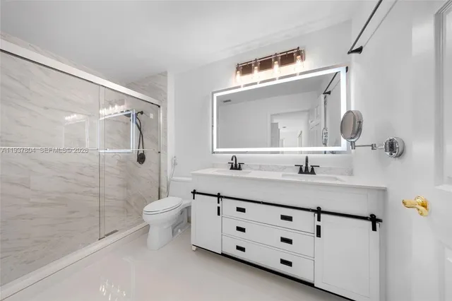 a bathroom with a double vanity sink toilet mirror and shower